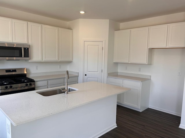 kitchen with a sink, light stone countertops, recessed lighting, and stainless steel appliances