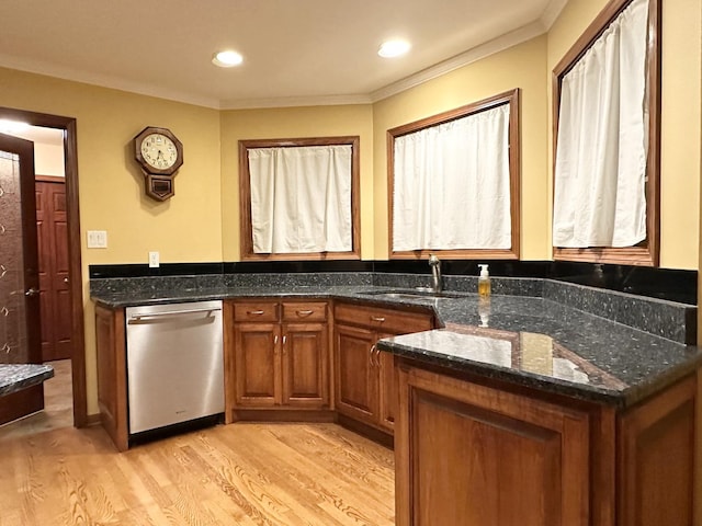 kitchen with light wood-type flooring, crown molding, sink, dark stone countertops, and dishwasher