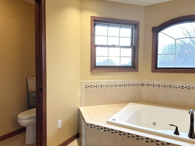 bathroom with tile patterned floors, a relaxing tiled tub, and toilet