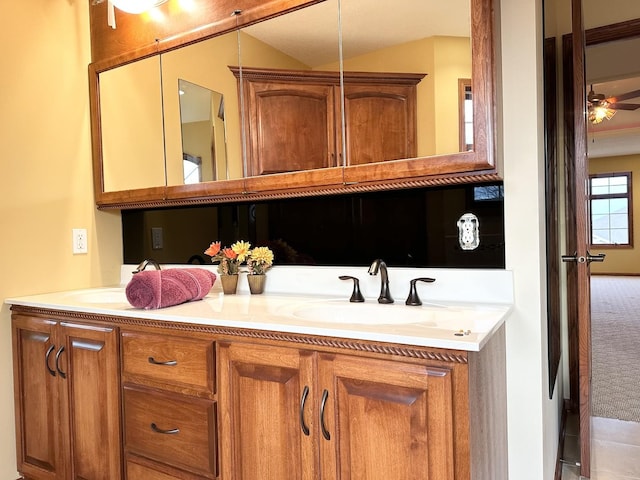 bathroom with vanity, ceiling fan, and vaulted ceiling