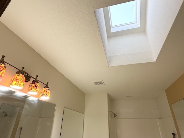 interior details with tiled shower and a skylight