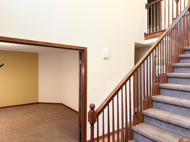 staircase with carpet and a high ceiling