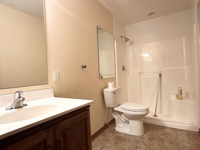 bathroom featuring tile patterned flooring, toilet, a shower, and vanity