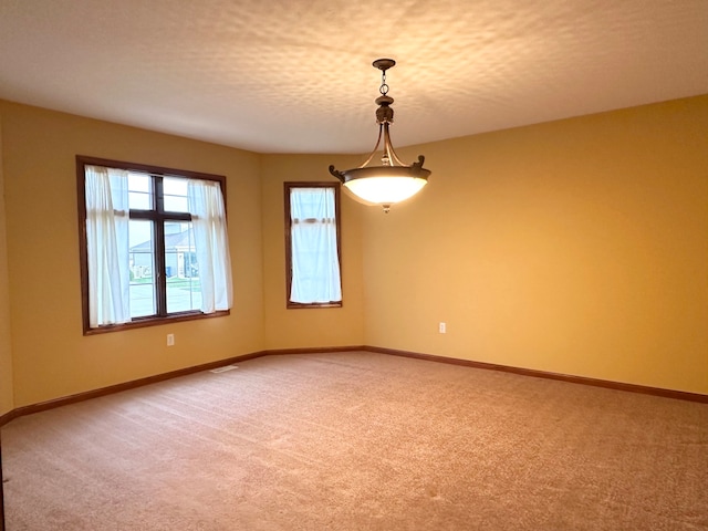 spare room featuring carpet floors and a textured ceiling