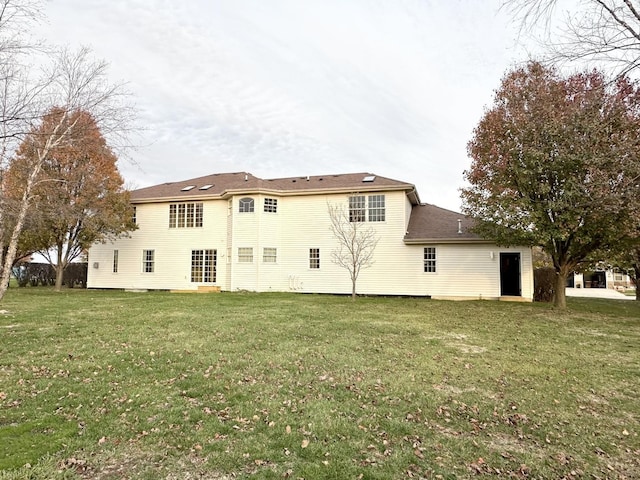 back of property featuring a lawn