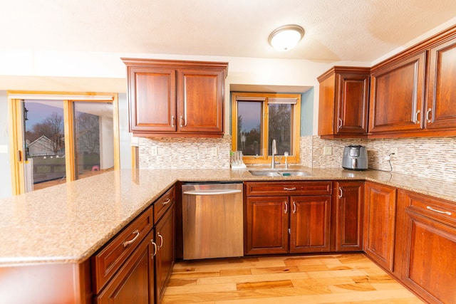 kitchen with dishwasher, backsplash, sink, light hardwood / wood-style floors, and kitchen peninsula