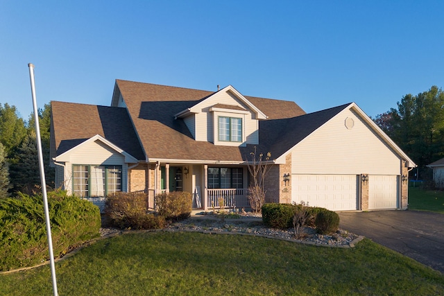 view of front facade featuring a garage, covered porch, and a front lawn