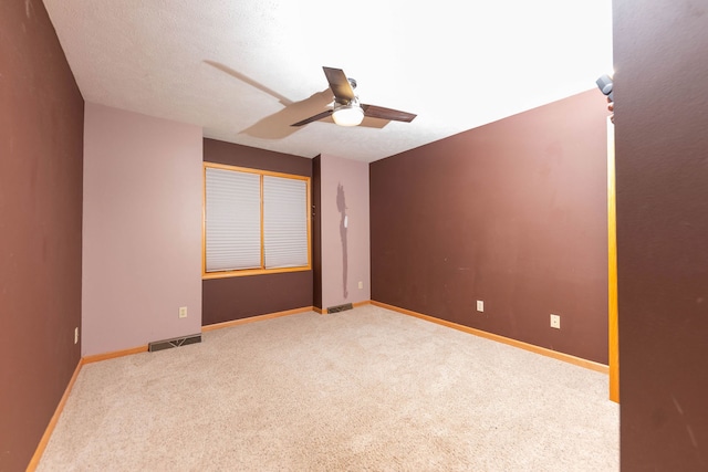 unfurnished room with light carpet, a textured ceiling, and ceiling fan