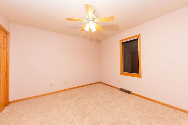 carpeted spare room with ceiling fan