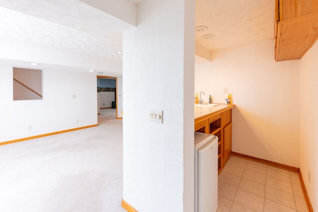 interior space with sink, light tile patterned floors, and a textured ceiling