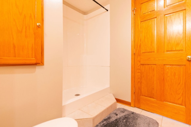 bathroom featuring toilet, tile patterned flooring, and walk in shower