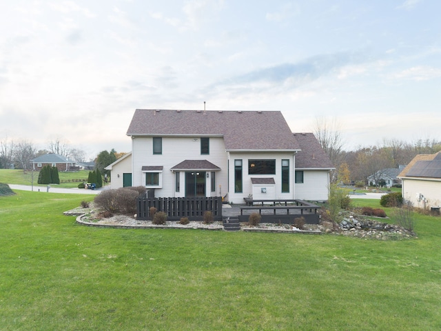 rear view of house featuring a deck and a yard