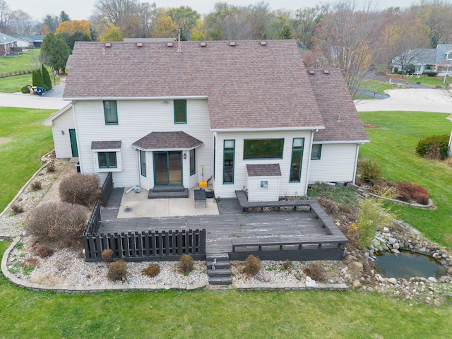 rear view of property featuring a wooden deck and a yard