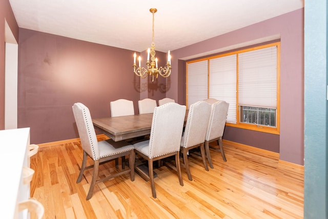 dining space with wood-type flooring and an inviting chandelier