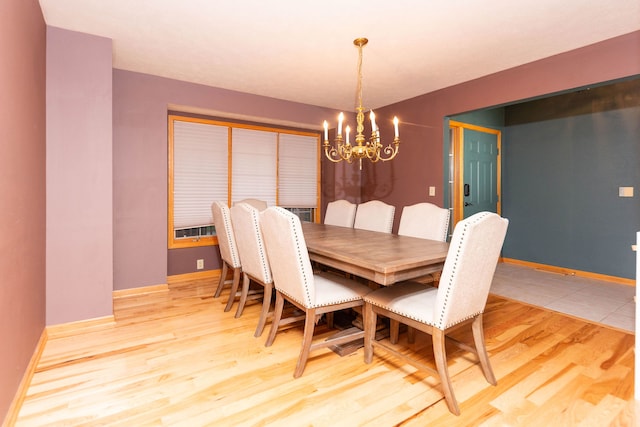 dining room with light hardwood / wood-style flooring and a chandelier