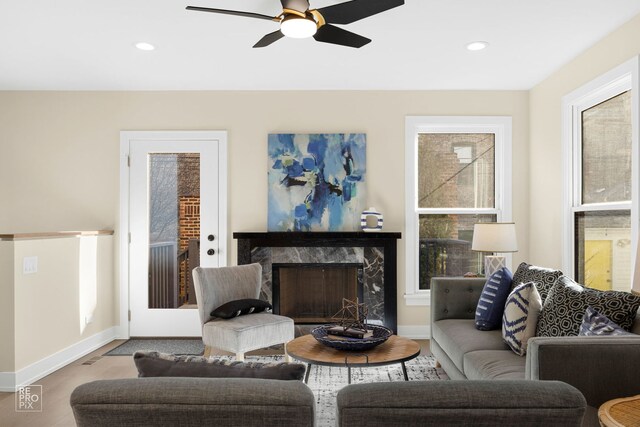 kitchen with pendant lighting, a center island, a premium fireplace, light hardwood / wood-style floors, and high end stove