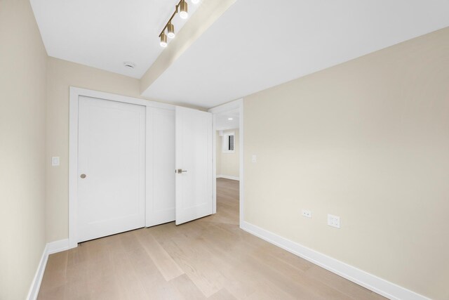 unfurnished living room featuring an inviting chandelier, light hardwood / wood-style flooring, and sink