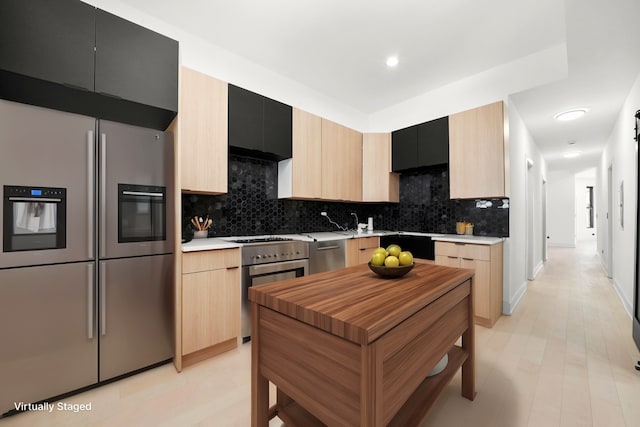 kitchen featuring light brown cabinets, stainless steel appliances, tasteful backsplash, and sink