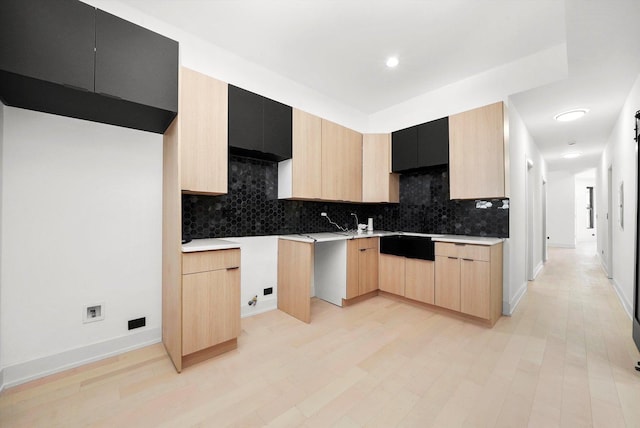 kitchen with backsplash, light brown cabinets, and light hardwood / wood-style floors