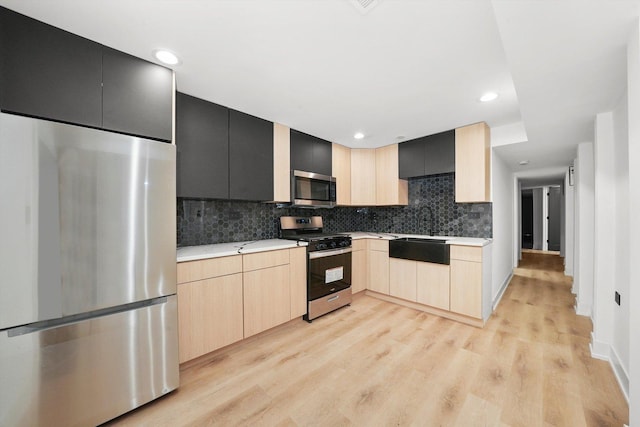 kitchen with sink, stainless steel appliances, light hardwood / wood-style flooring, decorative backsplash, and light brown cabinetry