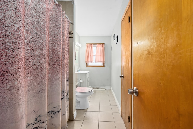 bathroom with toilet, vanity, and tile patterned floors