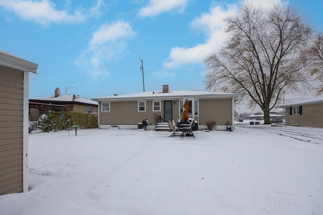 view of snow covered rear of property