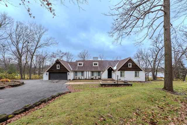 cape cod-style house with a front yard and a garage