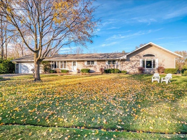 ranch-style house featuring a front yard and a garage