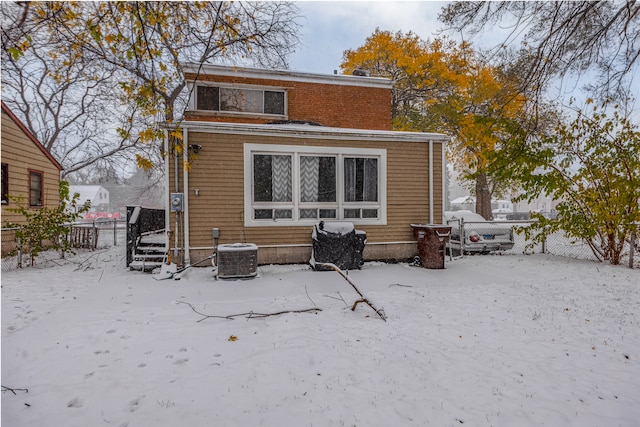 snow covered house with central air condition unit