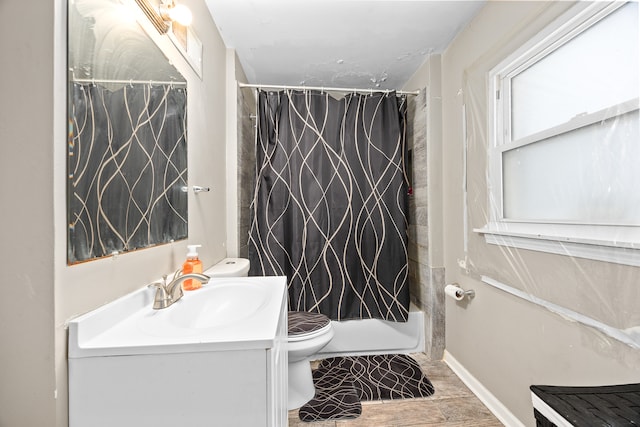 full bathroom featuring vanity, toilet, wood-type flooring, and shower / tub combo with curtain