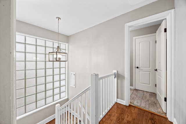 hallway featuring a chandelier and wood-type flooring