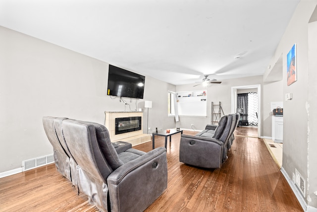 living room with a fireplace, hardwood / wood-style floors, a wealth of natural light, and ceiling fan