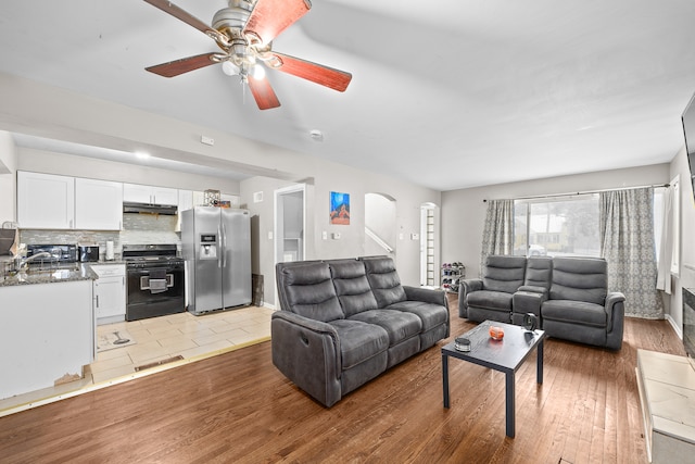 living room with light hardwood / wood-style flooring and ceiling fan