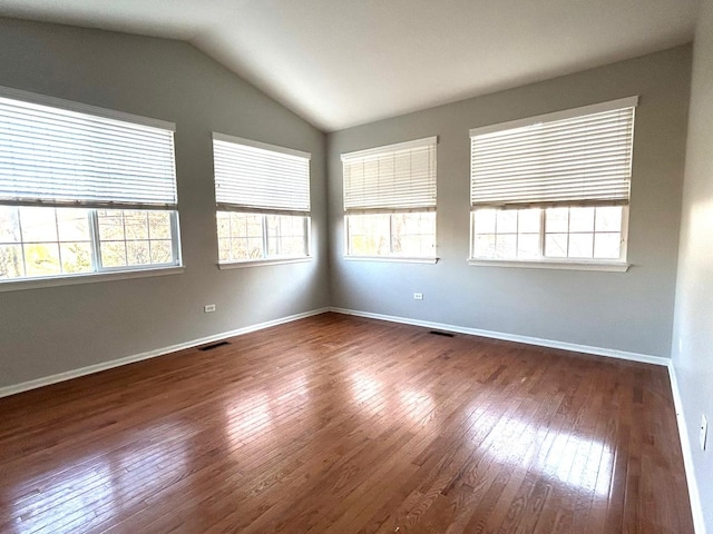 empty room with lofted ceiling and dark hardwood / wood-style floors