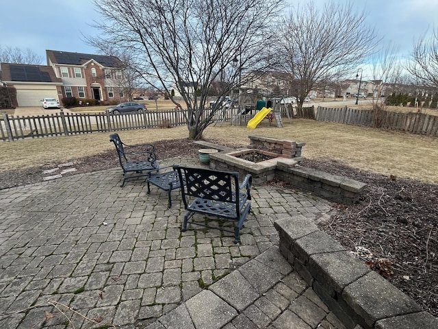 view of patio with a playground and a fire pit