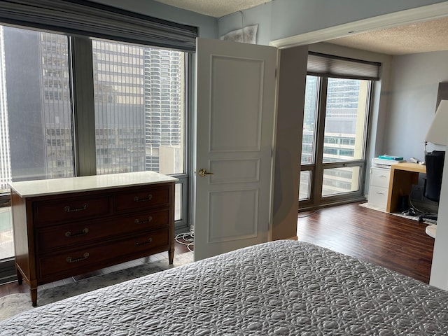 bedroom with a textured ceiling and dark hardwood / wood-style floors