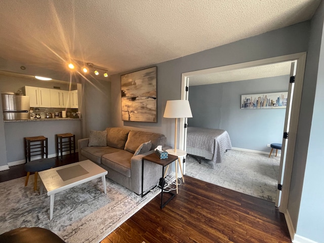 living room featuring dark hardwood / wood-style flooring and a textured ceiling