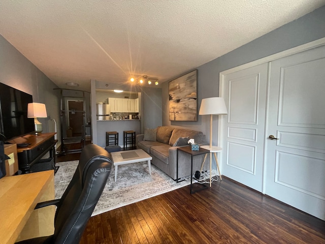 living room featuring a textured ceiling and dark hardwood / wood-style floors