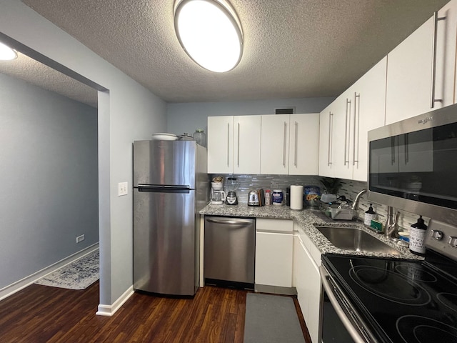 kitchen featuring dark hardwood / wood-style flooring, white cabinets, and appliances with stainless steel finishes