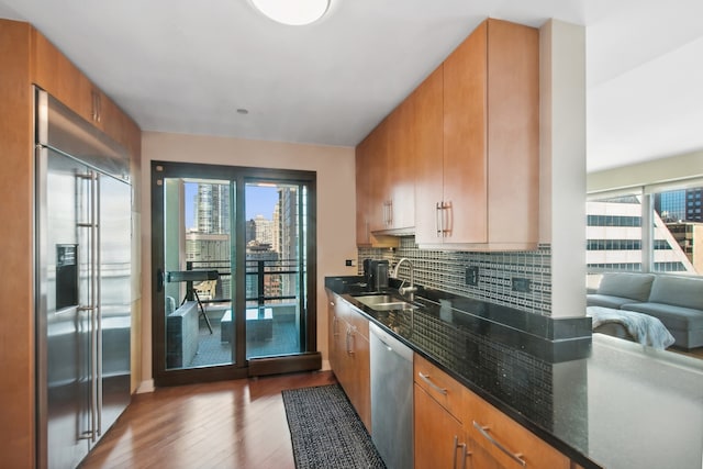 kitchen featuring a wealth of natural light, sink, hardwood / wood-style flooring, and appliances with stainless steel finishes