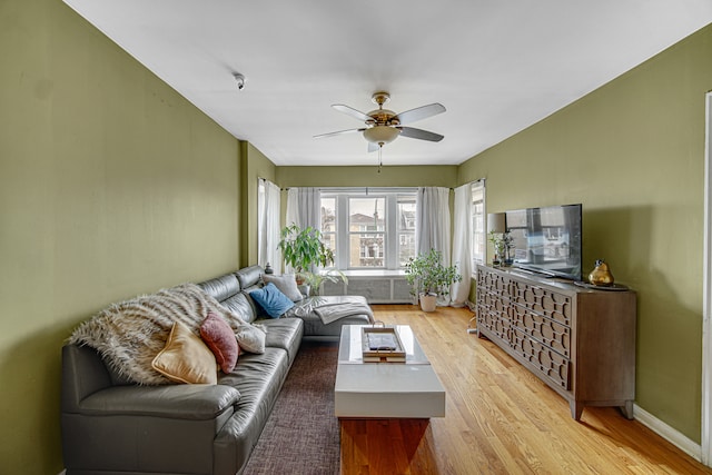 living room with ceiling fan and light hardwood / wood-style floors