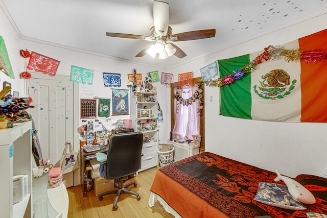 bedroom featuring ceiling fan, crown molding, and hardwood / wood-style flooring