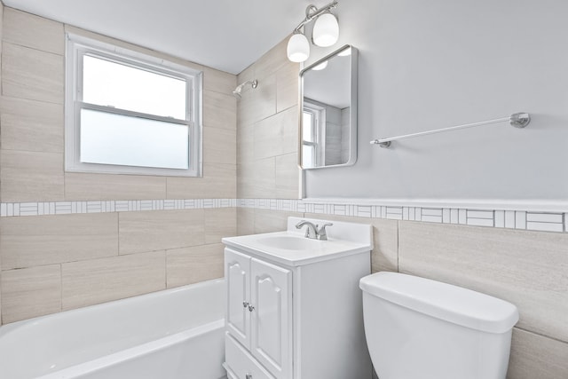 full bathroom with vanity, toilet, tile walls, and tiled shower / bath combo