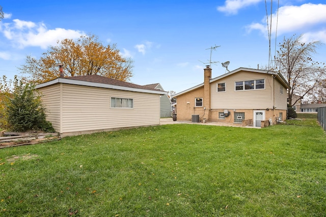 back of property featuring a yard and central AC