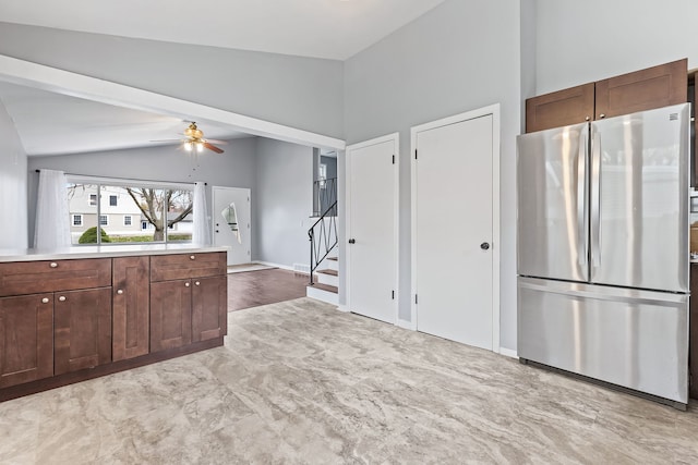 kitchen with stainless steel refrigerator, ceiling fan, dark brown cabinetry, and vaulted ceiling