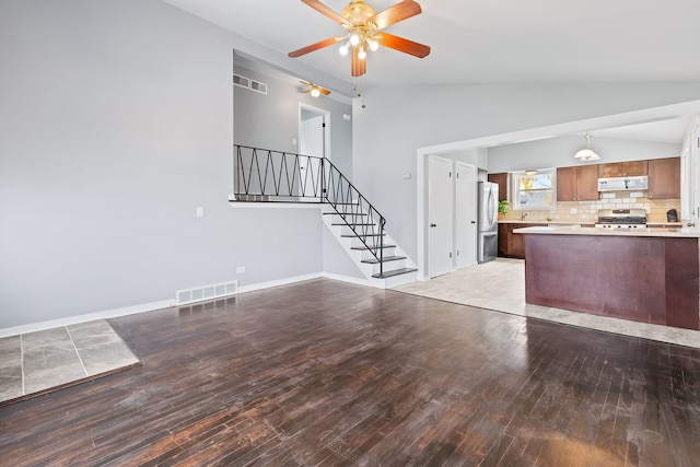 unfurnished living room with ceiling fan, light wood-type flooring, and vaulted ceiling