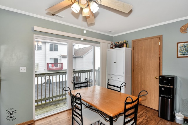 dining room featuring a wealth of natural light, crown molding, and hardwood / wood-style flooring