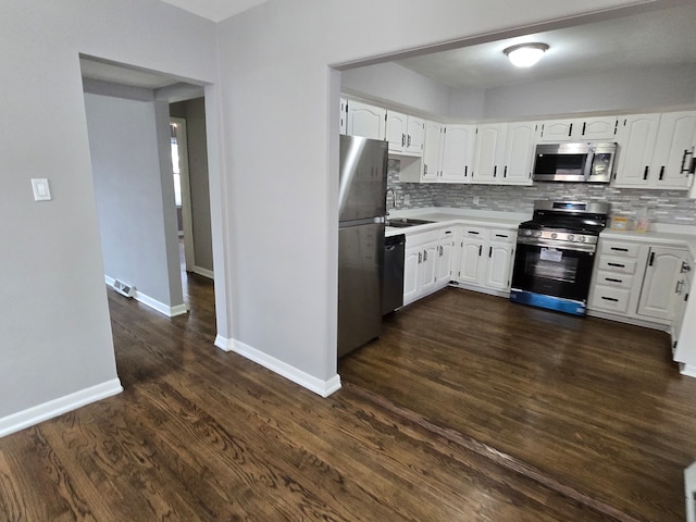 kitchen featuring appliances with stainless steel finishes, dark hardwood / wood-style flooring, and white cabinetry