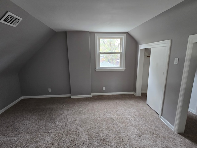 bonus room with carpet floors and vaulted ceiling