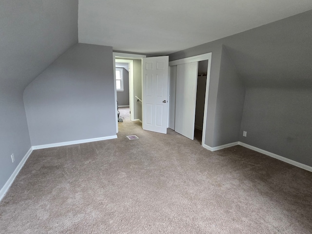 bonus room with carpet and vaulted ceiling